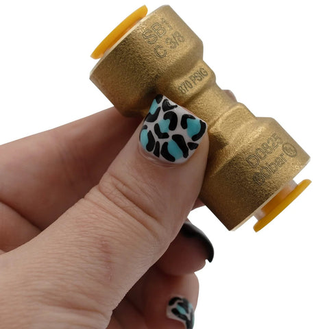 Brass SB1 3/8 in quick-connect HVAC coupler with yellow end caps, held in hand