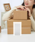 100 Pack White EPE Foam Pouches For Shipping Cushioning And Shockproof Packaging next to cardboard boxes on table.