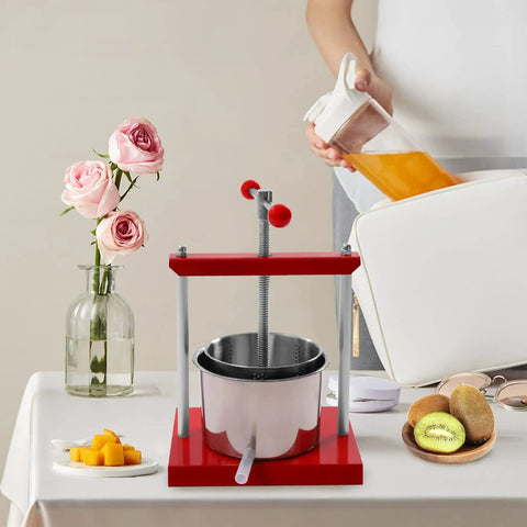 Heavy Duty 1.6 Gallon Stainless Steel Manual Press For Wine Cider Honey And Juicing on a table with fresh fruit and flowers.