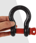 Hand holding a single black and red shackle from Six Piece Five Eighths Inch D Ring Shackles Heavy Duty Screw Pin Clevis For Towing And Off Road Recovery, Working Load Limit 3.25 Ton, Break Strength 13 Ton, Set Of Six.