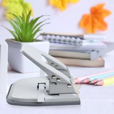 2 Hole Punch for Paper with adjustable guides on a desk, with a locking handle and metal design, next to office supplies