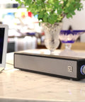 Vintage Wooden Mini PC Sound Bar With 3.5mm Aux, USB Powered Desktop Speakers For Monitor, Laptop, And Tablet Retro Style Delivers Crisp Stereo 2x5W Audio placed beside a laptop on a marble table.