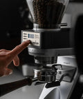 Close-up of the Straight Fire Conical Burr Coffee Grinder featuring Precision Grind By Weight Tech, showing the display and portafilter.