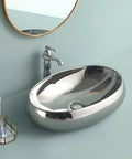 USZWBY Bathroom Vessel Sink European Ceramic Sink Art Basin Chrome Wash Basin Oval Sink close-up with faucet in silver.