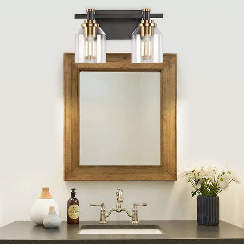 Slick Two Light Industrial Style Bathroom Vanity Light With Clear Glass Shades Matte Black Finish And Brushed Bronze Copper Accent Sockets above vanity mirror