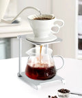 Straight Up Solid Folding Coffee Stand For Manual Espresso Machines Portable Aluminum Brewing Bracket pouring coffee into glass.