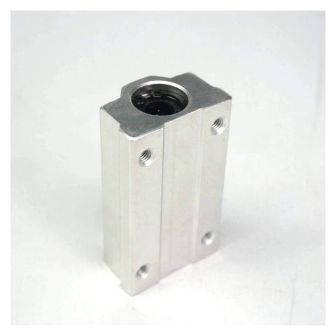 Linear bearing block in silver aluminum, angled front view showing side mounting holes and top bearing bore.