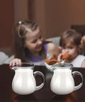 Two children enjoying breakfast with 8 Pack 4 Oz Glass Creamer Pitchers Set Clear Milk Pourers For Coffee Tea Syrups Mini Glass Pitchers