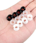 Hand holding 0G Ear Tunnels Kit Ultra Thin Silicone Flesh Flexible Gauges Set Of 6 Pairs Clear White Black For Piercing Expansion Plugs