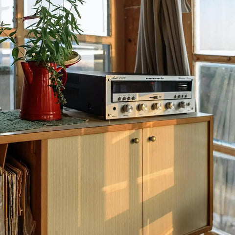 Wooden cabinet with vintage audio receiver and plant. Set Of 12 Sleek Round Antique Brass Cabinet Knobs For Rustic Farmhouse To Modern Kitchen Upgrades, Minimalist Hardware That Adds Warm Vintage Charm, Durable 1 Inch Diameter Knob Set For Cabinets And Drawers.