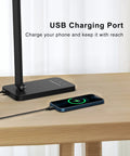 LED Desk Lamp With USB Port For Home Office And Reading, Eye Caring Light With 5 Color Modes And 5 Dimmable Levels, Touch Control And Auto Timer, Piano Style Modern Table Lamp showing USB charging port with phone charging.