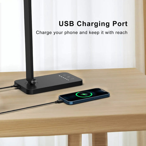 LED Desk Lamp With USB Port For Home Office And Reading, Eye Caring Light With 5 Color Modes And 5 Dimmable Levels, Touch Control And Auto Timer, Piano Style Modern Table Lamp showing USB charging port with phone charging.