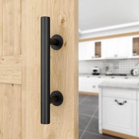 Close-up of 12-inch matte black solid steel barn door handle in kitchen setting, part of two pack sliding barn door handles kit.
