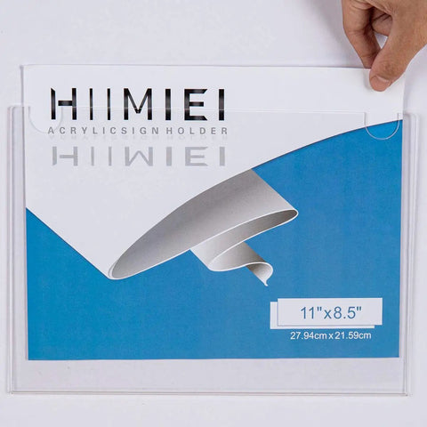 Person inserting paper into Clear Acrylic Wall Mount Sign Holder 8.5 By 11 Inches Horizontal, showing blue background.