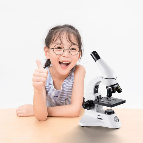 Child smiling with 100X To 2000X Educational Compound Microscope For Adults And Kids With 12 Magnification Options, white color.