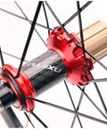 Close-up of red hub and carbon spokes of 700C Carbon Rear Wheel For Road Bikes With Quick Release Hub 130mm 21H Fits 8 9 10 11 Speed Cassette CV Brake 40mm Double Wall Rim Sealed Bearing Black Weighs 1050g.