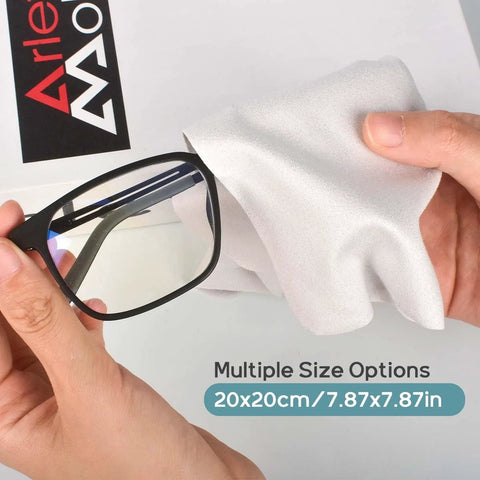 White microfiber eyeglass cleaning cloth, 20x20 cm, shown wiping a black glasses frame.