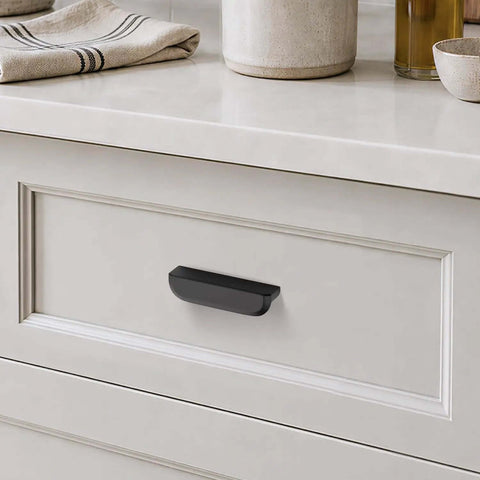 Top Shelf Heavy Duty 3 Inch Matte Black Cabinet Pulls 10 Pack on a dresser drawer with beige counter decor.