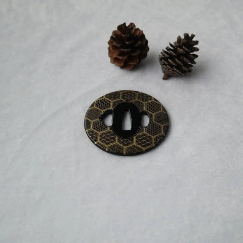 Iron Carved Tsuba Koshirae For Samurai Sword TDH 010 2.95 Inch Guard with decorative pattern and two pine cones in the background