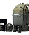 Flipside Trek BP 450 AW Camera Backpack With All Weather Cover, grey and dark green, beside camera and lenses, front view.