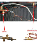 Interior view of propane fire pit gas assembly showing valve, thermocouple, flexible line, and nozzle
