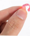 Close-up of a pink numbered band from 200 Piece Pigeon Identification Bands Set With Lightweight Numbered Leg Rings For Quail And Small Birds, Durable Clip Design For Easy Breeding And Tracking.