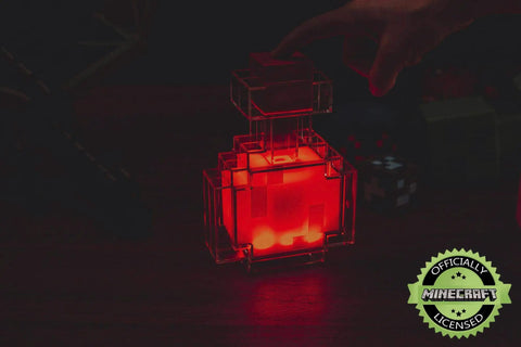Potion Bottle Color Changing LED Desk Lamp With Pixelated Design, 7 Inch Night Light glowing red, positioned on a desk.