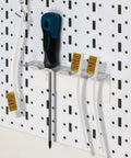 Pro Grade Three Pack Brass Wire Brush Set For 3D Printer Nozzle Cleaning on a pegboard, showing curved handles and brass bristles