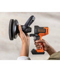 Hands holding Matrix 20V Max Buffer Kit For Cars Floors And Furniture With 3500 RPM Random Orbital Polisher, cordless, orange.
