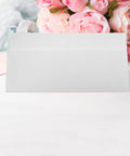 White Self Seal Confidentiality Envelopes 115mm By 225mm for office use, displayed with floral background