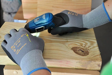 Maxiflex PIP Large Ultimate Micro Foam Nitrile Coated Work Gloves with Nylon Liner gripping a tool on wood