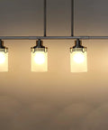4 Light Kitchen Island Pendant Chandelier In Brushed Nickel Finish With Frosted Glass Cup Shades on dark background