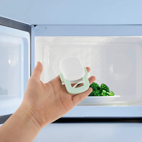 Hand holding Four Pack Childproof Oven Safety Locks For Cabinets And Microwaves Durable ABS Kitchen Locks near microwave