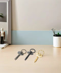 Steel and brass decorative key-shaped desk tools on a modern office desk.
