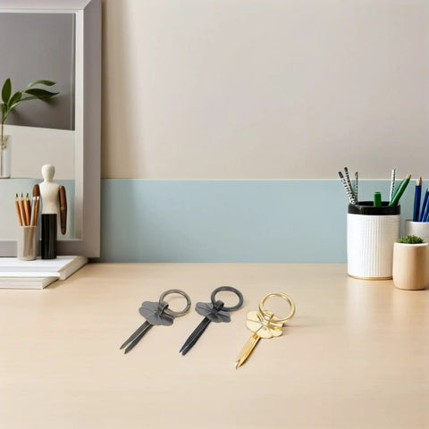 Steel and brass decorative key-shaped desk tools on a modern office desk.