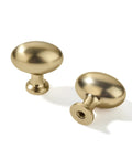 Two oval 1-3/8 inch brushed brass cabinet knobs with a zinc alloy core, ideal for kitchen makeovers and easy installation.