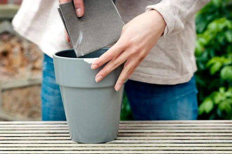 Person repairing a chipped gray pot using Epoxy Repair Putty For Quick Fixes Handy Two Part Moldable Adhesive That Bonds To Damp Surfaces