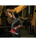 Man using Badass Heavy Duty Cordless Grease Gun Kit with 48-inch hose to lubricate heavy machinery in workshop.