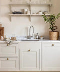 Real Deal Antique Brass Cabinet Knobs 1 1/4 Inch Round Sunburst Design, vintage hardware on white kitchen cabinets.