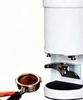Heavy Duty Automatic Coffee Tamper Machine Featuring Stepless 13 To 16 Lb Pressure Dial And Premium 58Mm Electric Espresso Base For Nailing The Perfect Shot In White with coffee grounds in portafilter.