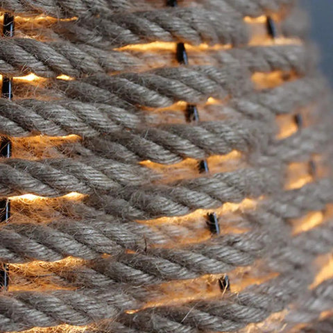 Close-up of Coastal Rope Rattan Handwoven Pendant Lamp In Natural Finish, showcasing woven texture and warm light glow.