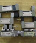 Hydraulic control valve pack 6-piece repair set for parts or refurbishment, showing six industrial valves on a wooden surface.