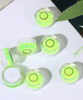 10pcs Circular Bubble Spirit Level for Calibration Picture Frame, round acrylic levels with bright green bubbles on a flat surface.