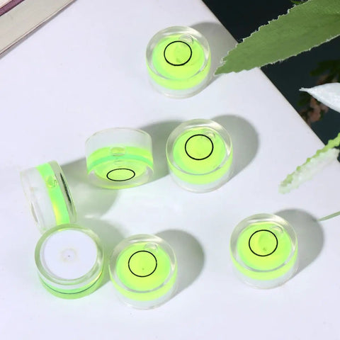 10pcs Circular Bubble Spirit Level for Calibration Picture Frame, round acrylic levels with bright green bubbles on a flat surface.