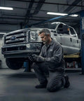 Mechanic with Ford 4 Lug Rear Axle Nut Socket Wrench For F Series Trucks Ten And A Half Inch Spindle Nut Size Two And Three Quarter Inch Outer Heavy Duty Hub Nut Tool For Quick DIY Removal And Installation On F 250 And F 350 Models beside lifted truck
