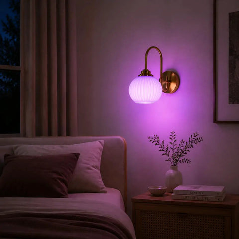BOKT Ribbed Glass Battery Operated Wall Sconce Set of 2 with 12 RGB Colors illuminated in purple beside a bed.