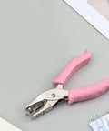 6mm Handheld Single Hole Punch For Paper With Durable Metal Body And Rubber Grip Handle on desk with paper clips