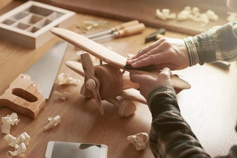 Person sanding wooden model plane with Assorted Sandpaper Sheets 400 600 800 1000 1200 1500 Two Sheets Each Dry Wet Waterproof 9 x 3.6 Inch For Wood Furniture Hobbies And Home Improvement Pro Grade Sanding Set Perfect For Sanding Polishing Plastics Glass.