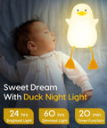 Baby sleeping next to Squishy Duck Night Light For Kids With Soft Warm Glow Silicone Dimmable Nursery Lamp on bed.