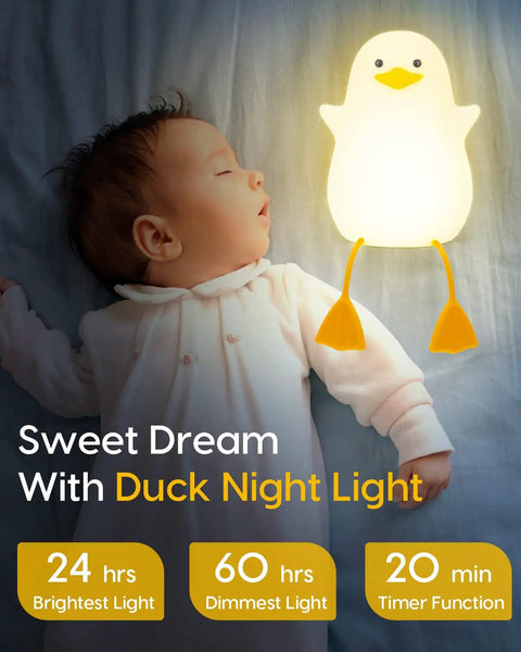 Baby sleeping next to Squishy Duck Night Light For Kids With Soft Warm Glow Silicone Dimmable Nursery Lamp on bed.